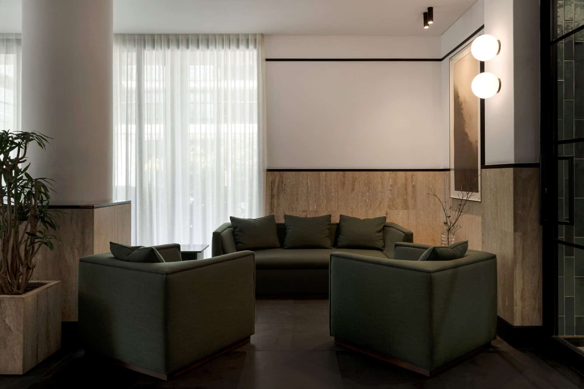 Green leather lounge seating below sheer curtains at Rosetta Roastery