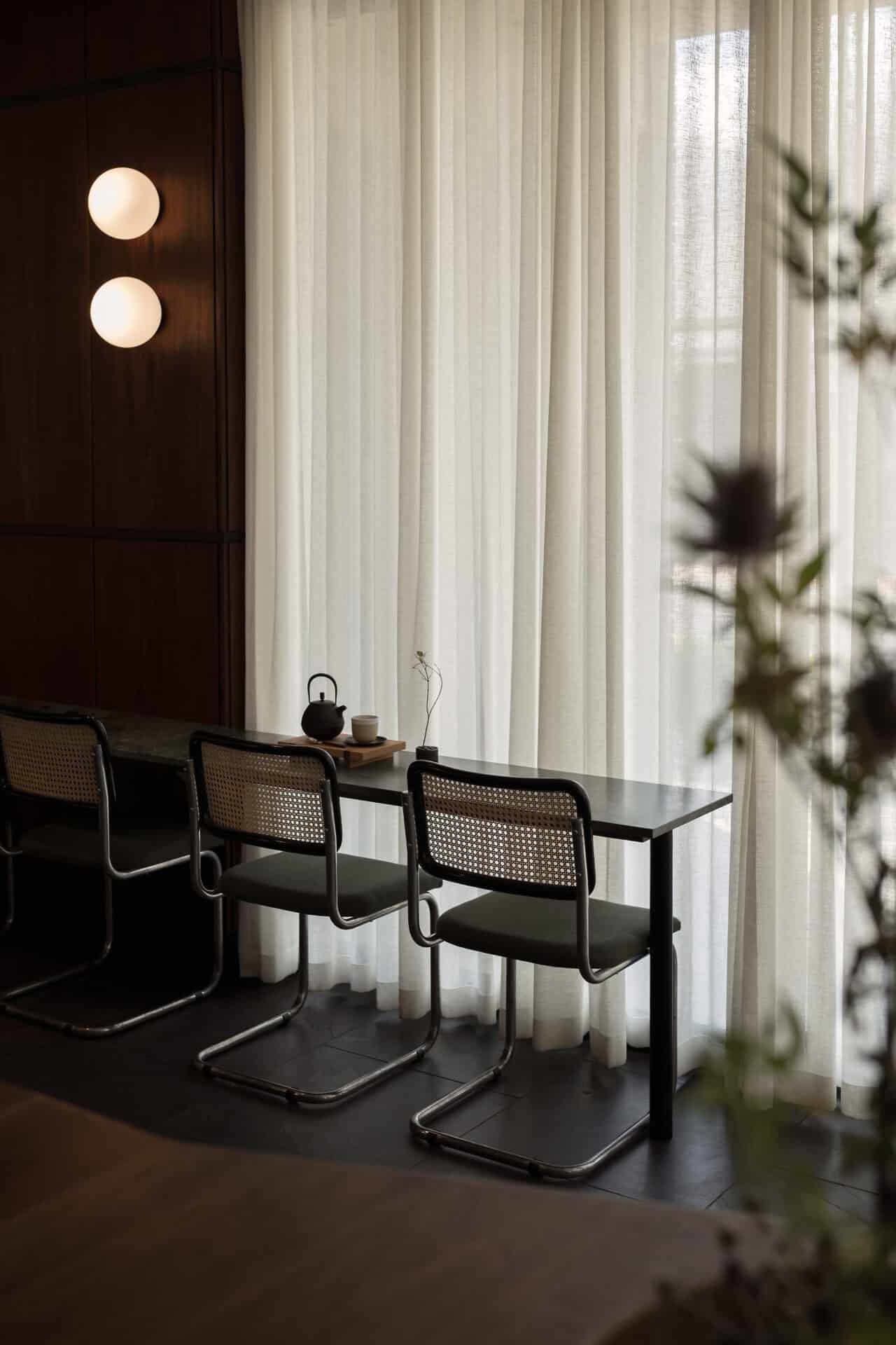 Cane chairs and timber tables along the window at Rosetta Roastery