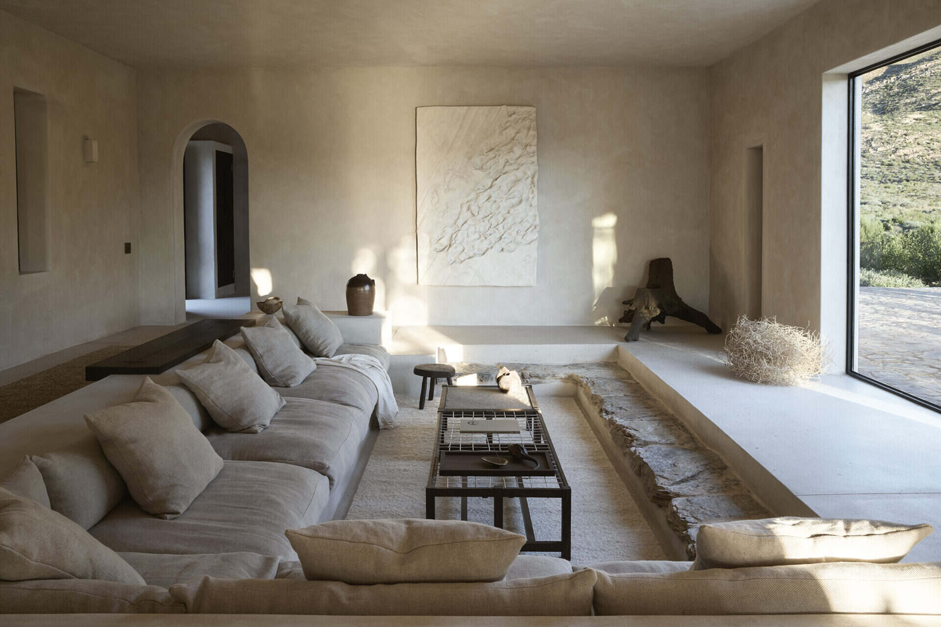 Living room at Mura with low linen seating facing a picture window onto the Klein Karoo