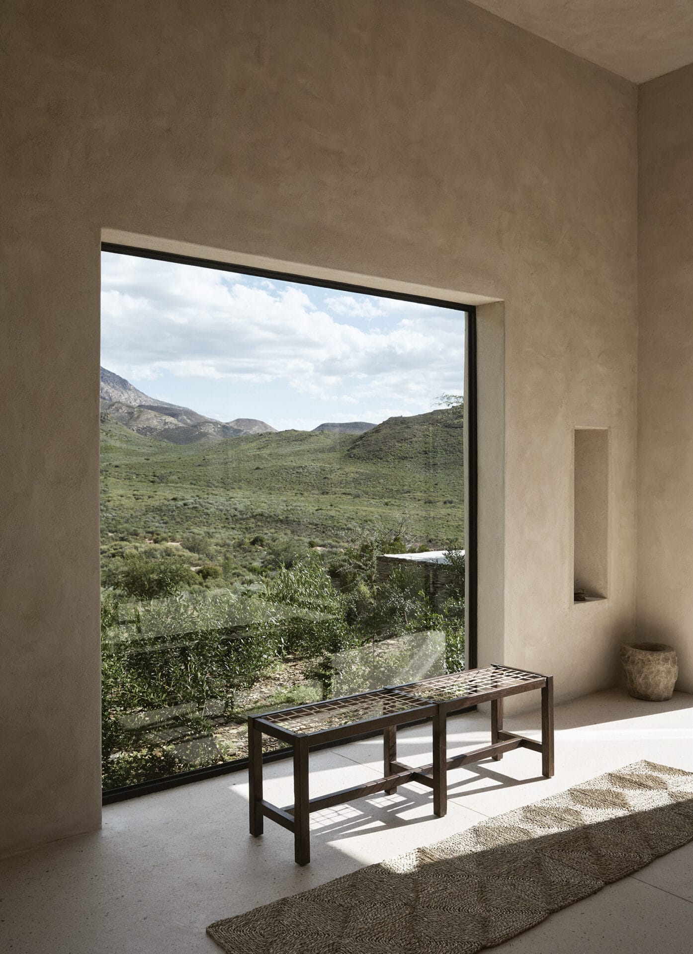 Picture window at Mura framing the Karoo, with a slatted bench below