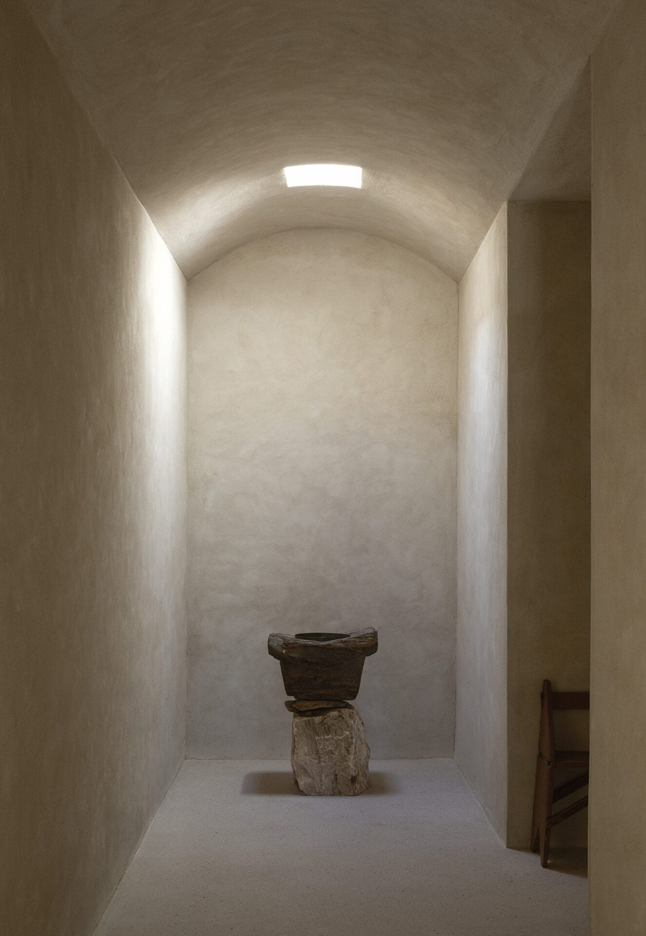 Vaulted plaster corridor at Mura ending in a carved stone vessel