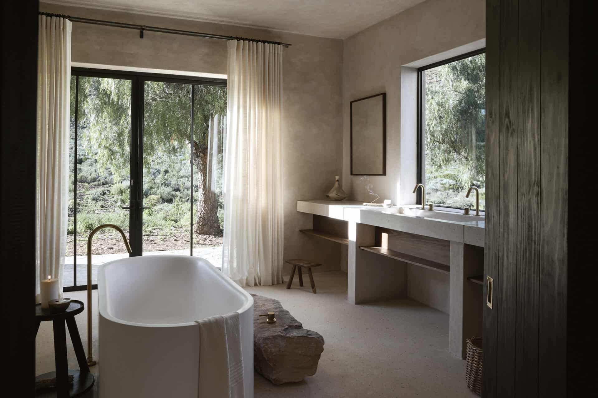 Main bathroom at Mura with a freestanding bath and doors onto the garden