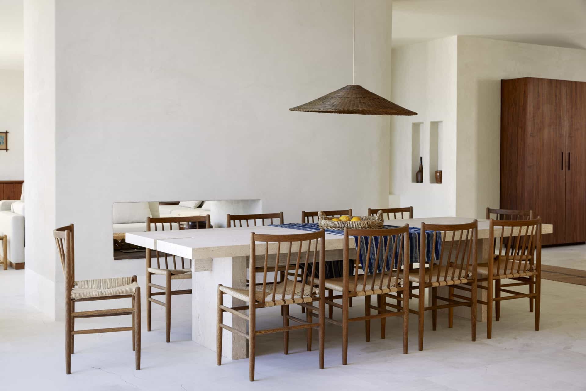 Dining room at House T with a woven pendant above a pale timber table