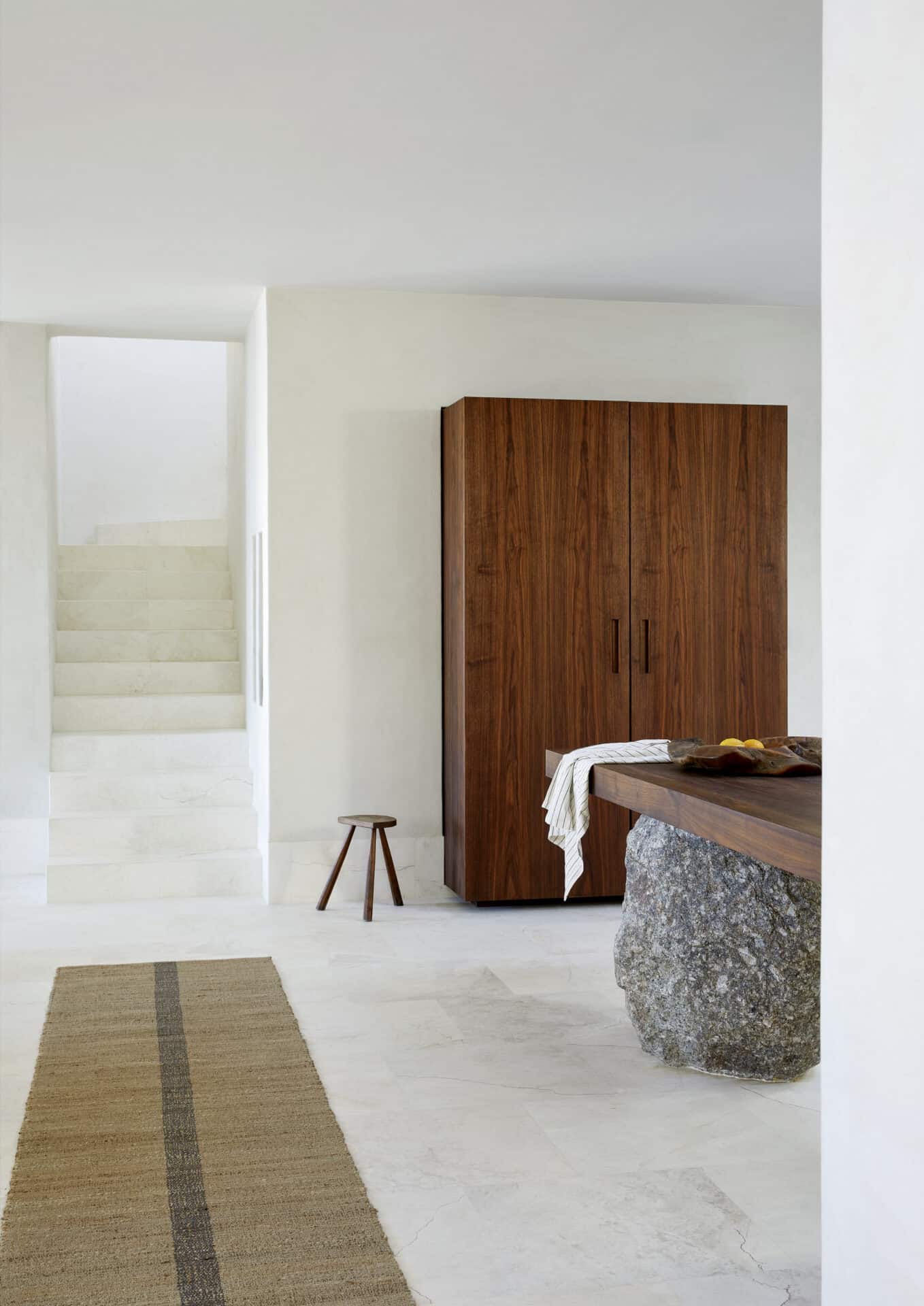 Timber cabinet and stone-footed table in the hall at House T