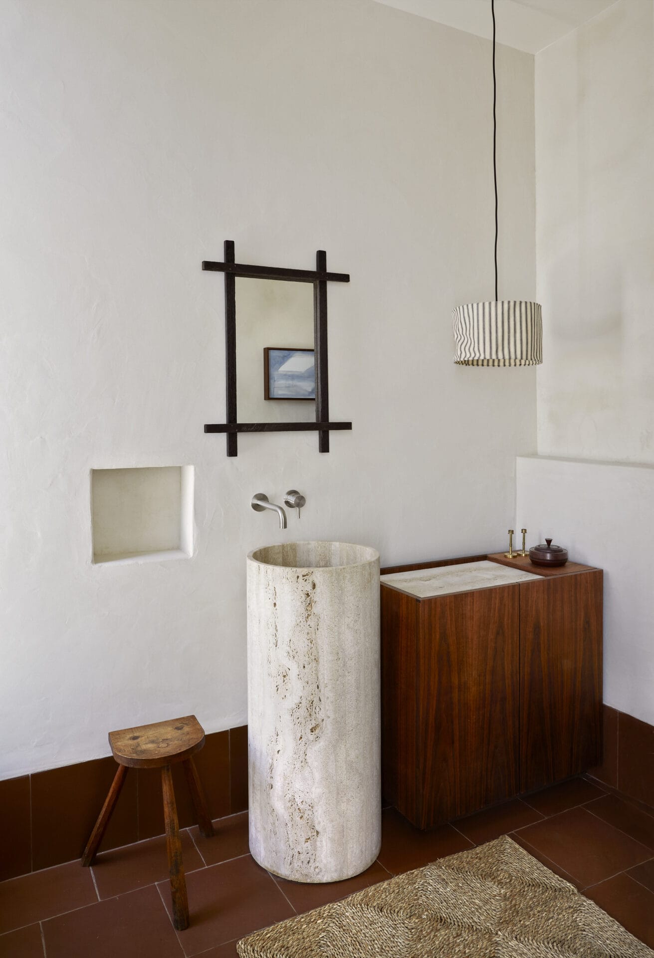 Stone pedestal basin and dark timber vanity in a bathroom at House T