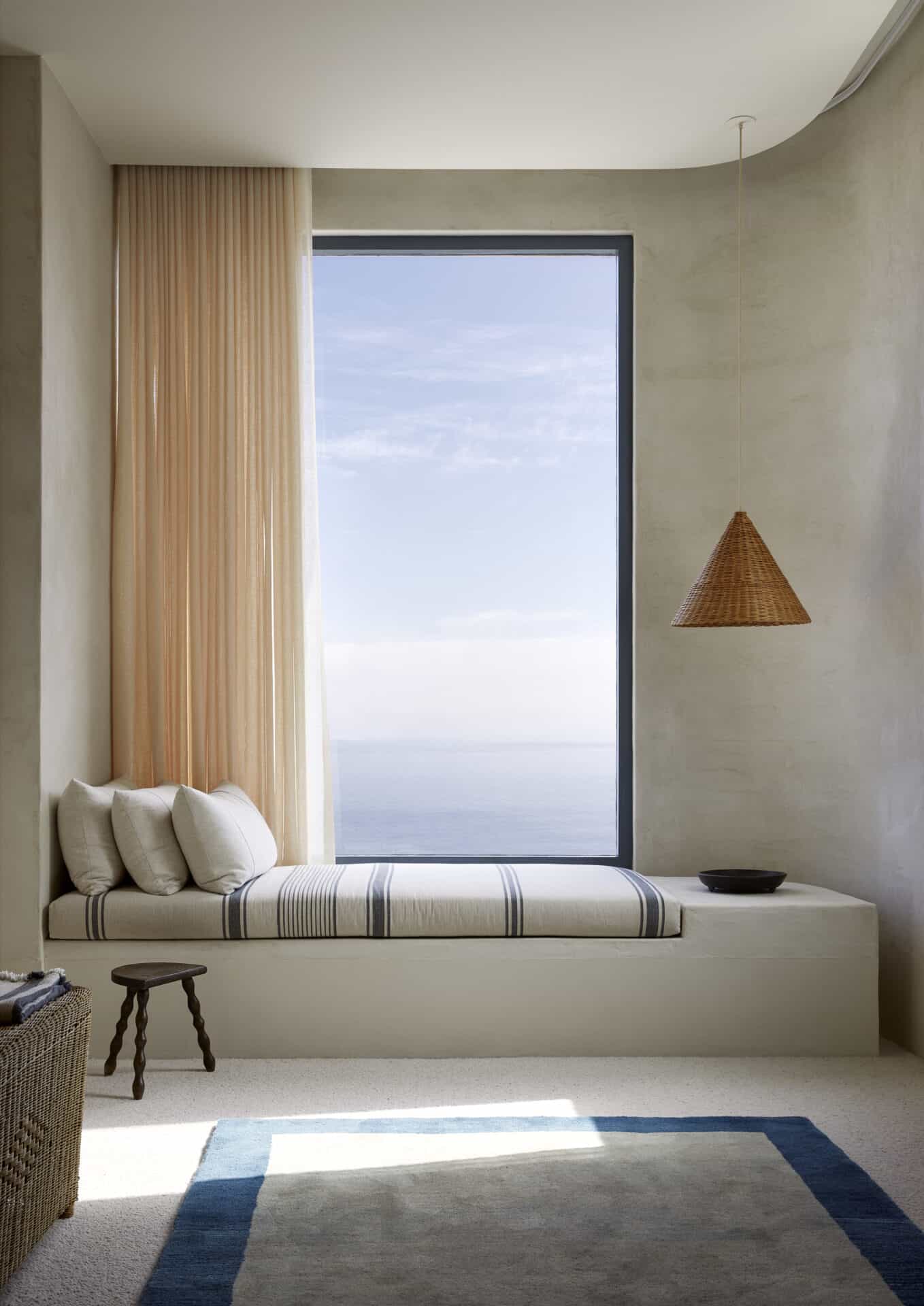 Window seat at House T overlooking the Atlantic, with a woven wall light